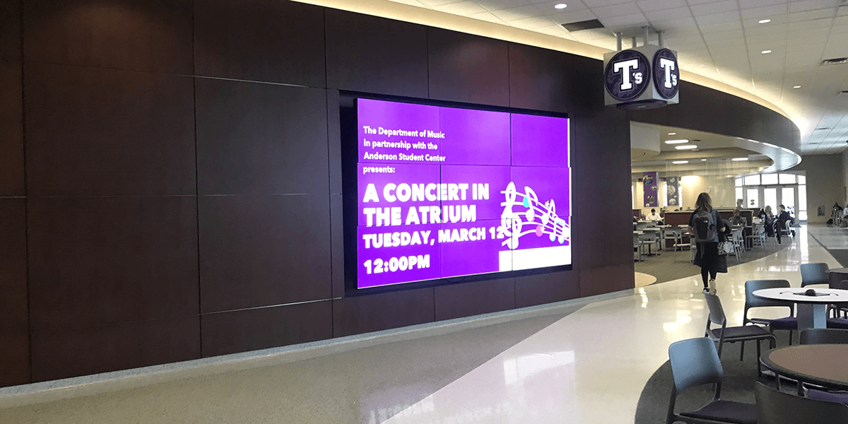 Purple digital video wall displayed within a university's department of music