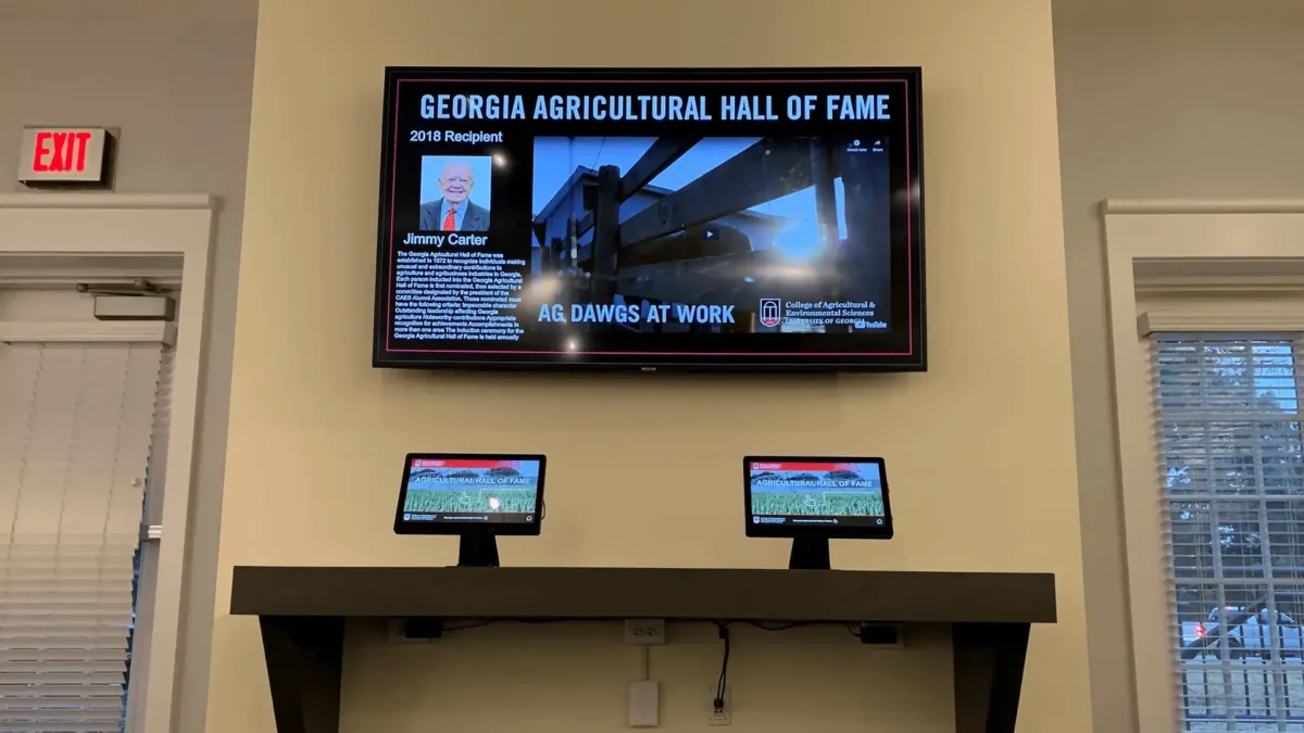 College of Agriculture & Environmental Sciences digital signage screen featured above hall of fame ipads and displaying hall of fame member Jimmy Carter.