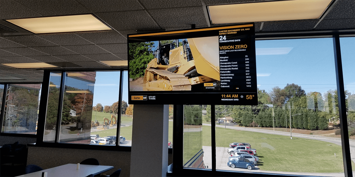 Customer example of a black and orange breakroom digital signage that features employee statistics