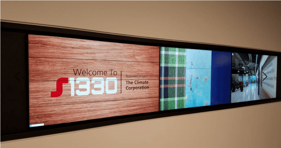 videowall example S1330 Corporate digital signage video wall displaying a welcome message and images of the office interior.