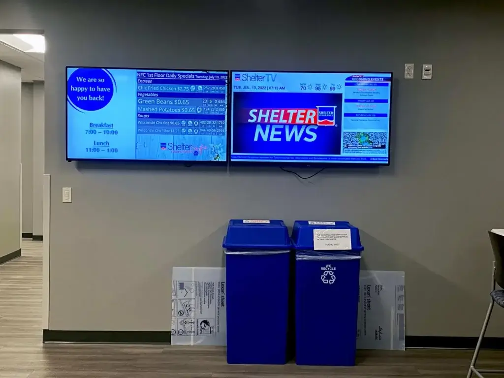Two wall-mounted displays, powered by REACH Media Network.