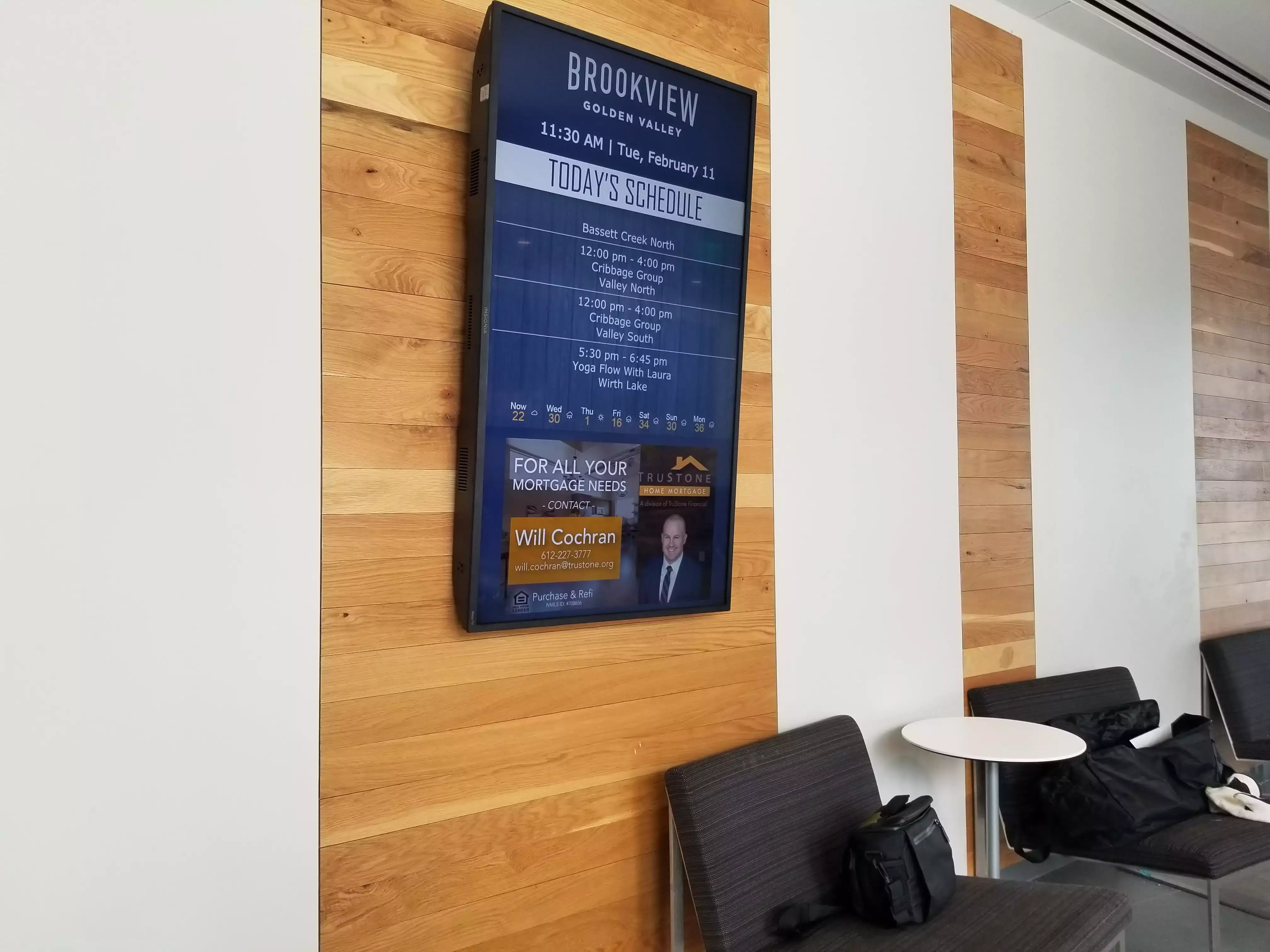 Blue lobby digital signage displaying the daily schedule for Brookview Golden Valley