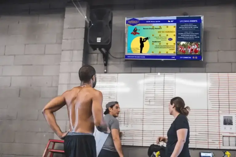 Faribault rec center digital signage screen from Reach Media Network featured above dry-erase board.