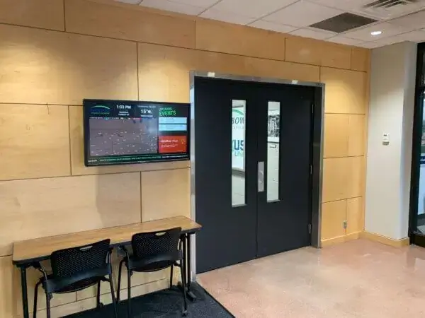Rainbow Energy Group digital signage featured in breakroom, Reach Media Network case study, displaying radar, upcoming events, and trivia