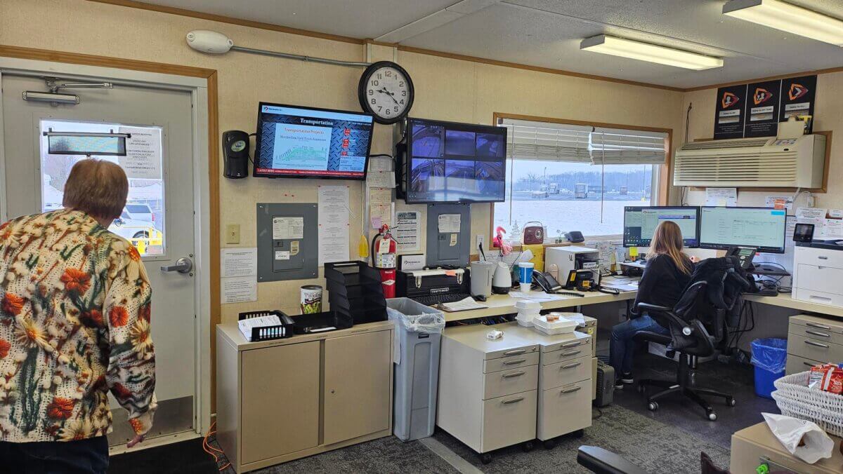 Steel Dynamics case study digital signage office display showing transportation info, calendar events, and news ticker