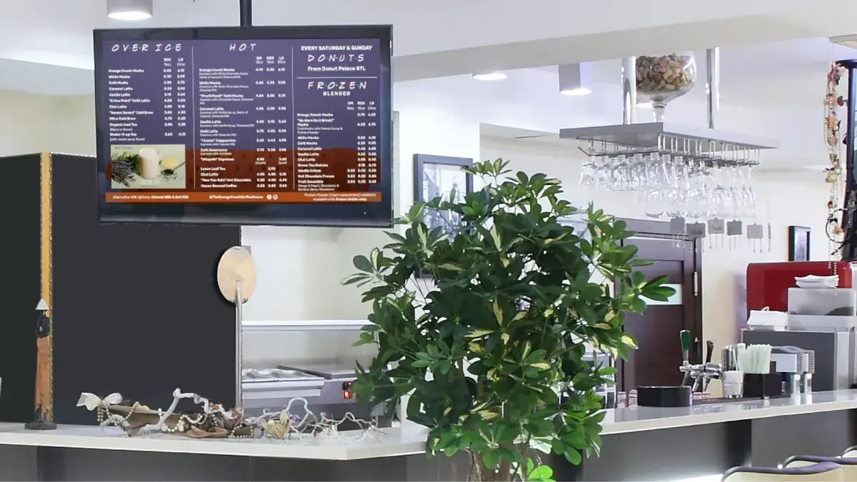 Coffee shop digital signage menu board from Reach Media Network featured above a restaurant bar.