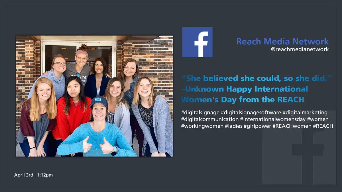 Digital signage screen displaying REACH Media Network Facebook social media post and image of women team members for Women's Day.
