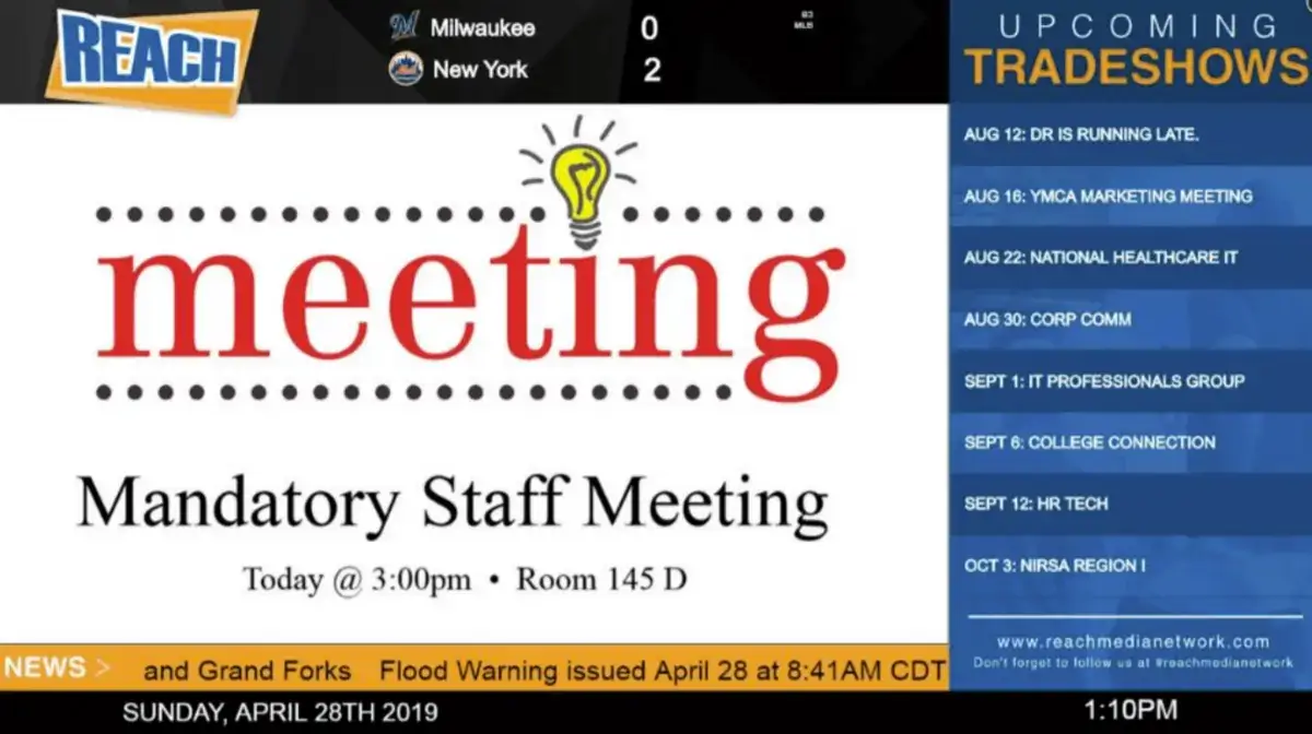 REACH Media Network digital signage screen displaying weather alert, upcoming tradeshows, mandatory staff meeting announcement, and news headlines.
