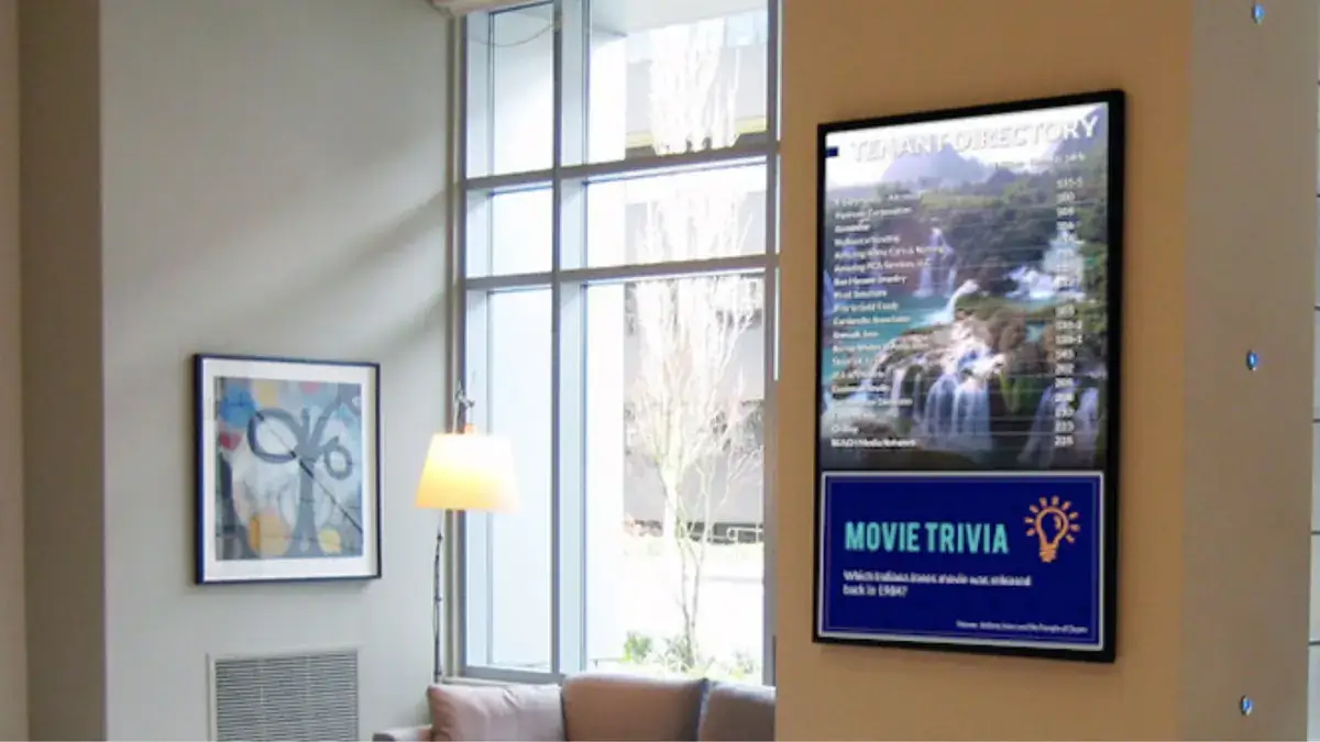 Digital signage from Reach Media Network displaying building directory and movie trivia facts.