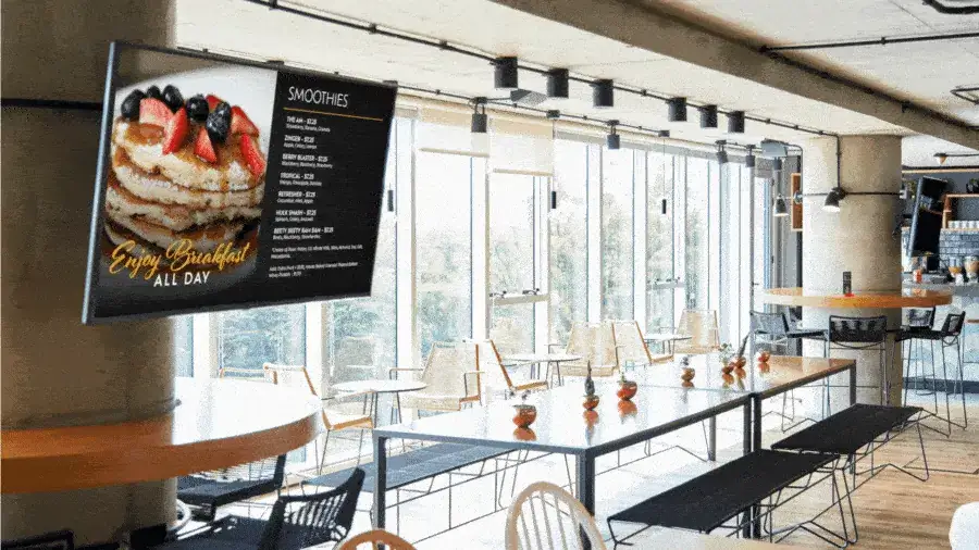Reach-Media-Network-menu-board-digital-signage-solutions Wall-mounted digital display showcasing a restaurant's menu and food media.